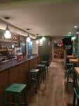 Vista del interior de Bar Argallo con barra y mesas al fondo