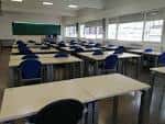 Aula o sala de reuniones equipada con mesas y sillas
