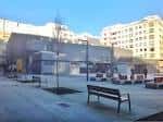 Vista amplia de la Praza das Conchiñas con el mercado al fondo y bancos