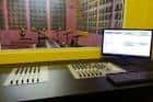 Sala de control de radio con mesa de mezclas y monitor
