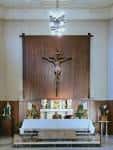 Altar mayor de la Parroquia de Santa Teresita con crucifijo y candelabros