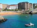 Embarcación en las aguas de la Playa de San Amaro con la costa al fondo