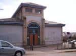 Fachada principal de la Sala de Exposicións Porta Miñá con entrada arqueada