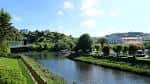 Vista amplia del Río Mandeo en Betanzos con orillas verdes y edificios al fondo.