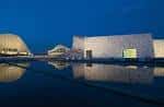 Cidade da Cultura iluminada de noche con reflejos en el agua