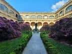 Jardín central del Pazo de Fonseca con sendero y flores moradas