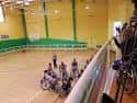 Vista interior del polideportivo con cancha de baloncesto y gradas