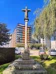 Cruceiro tradicional en la Praza de Bretaña de Lugo bajo un cielo azul.