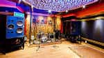 Sala de ensayo o escenario con batería e instrumentos