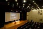 Auditorio o sala de conferencias con escenario y pantalla