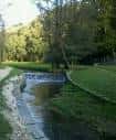 Río Rato con pequeña cascada artificial y orillas verdes