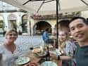 Grupo de personas disfrutando de una comida en la terraza exterior de la taberna