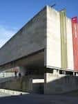 Vista exterior del Centro Galego de Arte Contemporánea con fachada de hormigón y estandartes.