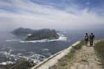 Senderistas en un camino con vistas al mar y las islas