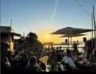 Ambiente animado en terraza de chiringuito al atardecer