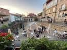 Terraza exterior o plaza adyacente con mesas y clientes disfrutando del espacio al aire libre