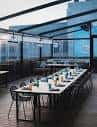 Terraza exterior cubierta con mesa larga dispuesta para eventos