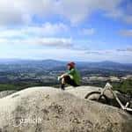 Ciclista descansando en la cima de Monte Castrove con vistas panorámicas