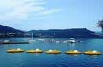 Pedaletas amarillas flotando en el lago de Castrelo de Miño con montañas al fondo
