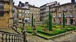 Jardín y edificios históricos en una plaza del casco antiguo de Santiago