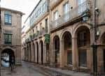 Perspectiva de la Rúa do Vilar con sus característicos soportales y edificios antiguos en un día soleado.