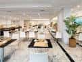 Salón interior moderno con mesas y sillas blancas, ideal para eventos
