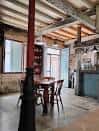 Zona de comedor de Nasantiña con pilar rojo y ambiente rústico