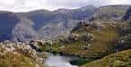 Vista panorámica de un lago y montañas verdes en Pena Trevinca