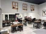 Zona de bar y cafetería con mesas y sillas