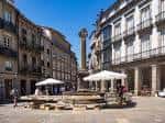 Praza de Cervantes en un día soleado con terrazas y actividad.