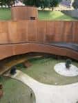 Vista aérea del patio circular exterior con jardín y muros de acero corten