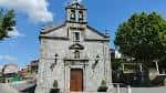 Vista frontal de la Iglesia de Santa Mariña de Cabral bajo cielo azul