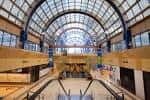 Interior del Centro Comercial Camelias con techo acristalado y escaleras mecánicas