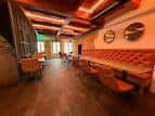 Interior de un local moderno con iluminación cálida y asientos tipo lounge, apto para eventos