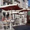 Terraza exterior del local con mesas, sillas y sombrillas