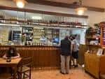Interior del Bar Estrella con la barra, botellas y clientes