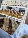 Primer plano de una mesa de catering con mini sándwiches y galletas en bandejas escalonadas
