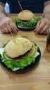 Dos hamburguesas servidas en platos individuales en una mesa