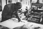Artista trabajando en una prensa de grabado en el taller de la Fundación CIEC