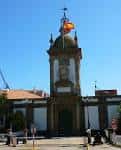 Vista frontal de la Puerta del Dique del Arsenal Militar de Ferrol con bandera española