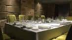 Mesa de comedor elegantemente preparada en sala con paredes de piedra
