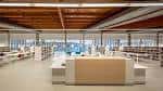 Interior de la Biblioteca Pública del Estado en Ourense, con mostrador de información y estanterías