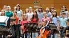 Coro de niños actuando en el salón de actos o gimnasio