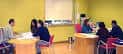 Sala de reuniones con personas en mesas redondas y paredes amarillas