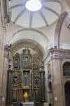 Interior de la iglesia mostrando el retablo mayor y la cúpula central