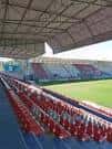 Perspectiva de las gradas del Estadio Anxo Carro con asientos rojos.