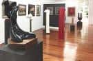 Espacio de galería con esculturas y pinturas en exposición