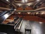 Vista del auditorio desde el escenario, mostrando un piano de cola