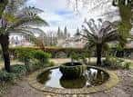 Fuente ornamental con palmeras y la Catedral de Santiago de Compostela al fondo en la Alameda
