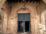 Entrada principal de la Iglesia de Santa María Salomé con puerta azul y arco de piedra